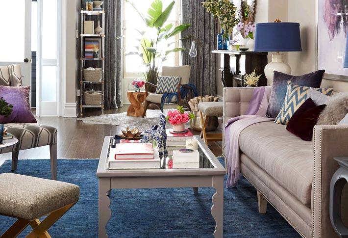 светлая мягкая мебель и синий ковер в гостиной комнате