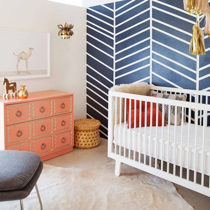 белые узоры на синей стене в детской для младенца