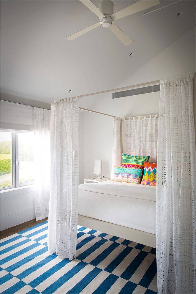 Кровать с пологом в белой спальне с вентилятором