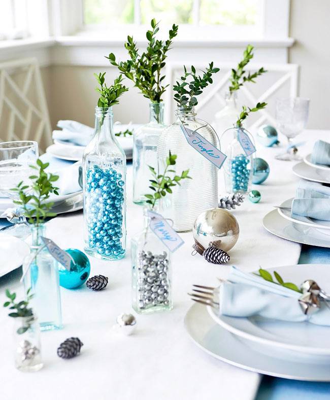 голубой цвет новогоднего декора со стеклянными бутылками на столе