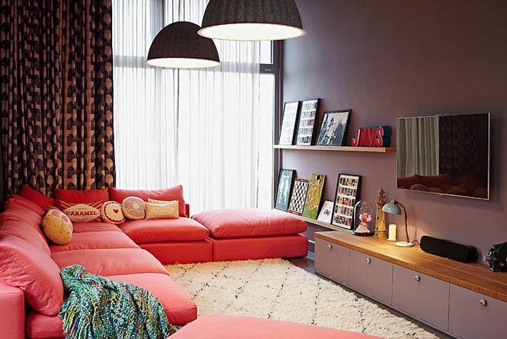 уютный интерьер гостиной с красным диваном