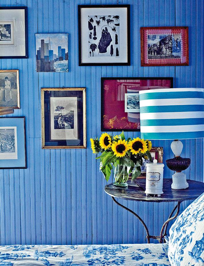 синий цвет стен в дизайне спальной комнаты с картинами