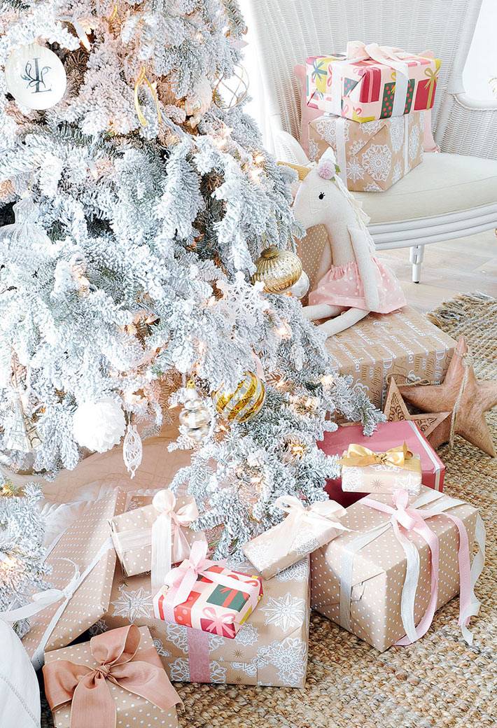 новогодние подарки под белой елкой в интерьере