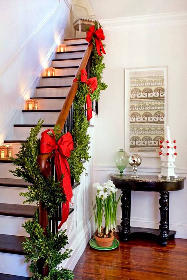 хвоя и красные банты на перилах лестницы к новому году