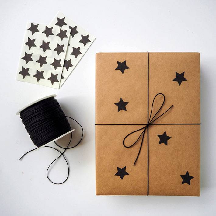 черные звезды на упаковочной бумаге для новогодних подарков