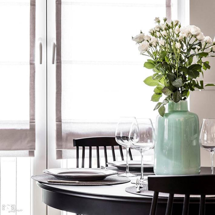 Красивая ваза с цветами на круглом обеденном столике фото