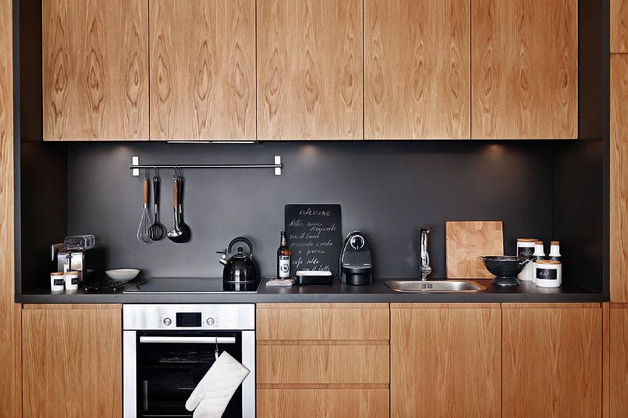 деревянные фасады кухни и черный кухонный фартук