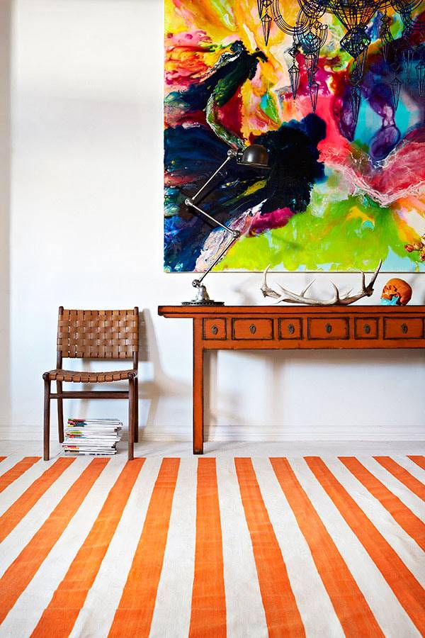 Яркий ковер с оранжевыми полосами в комнате фото