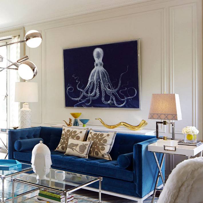 Синий диван в гостиной и два стеклянных столика фото