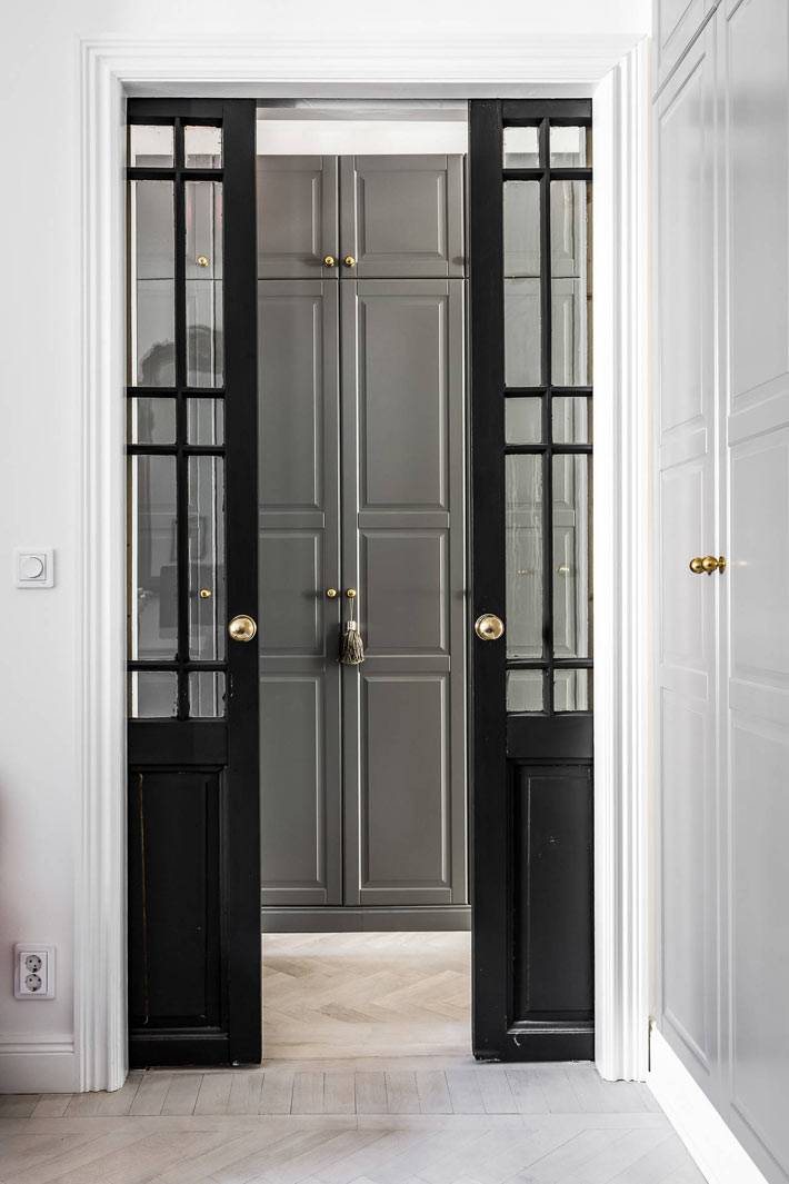красивая черная развижная стеклянная дверь в интерьере квартиры