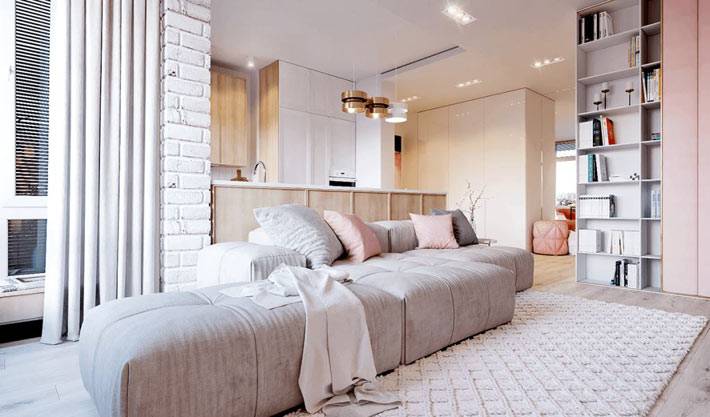 Квартира-студия в пастельных тонах с серым диваном