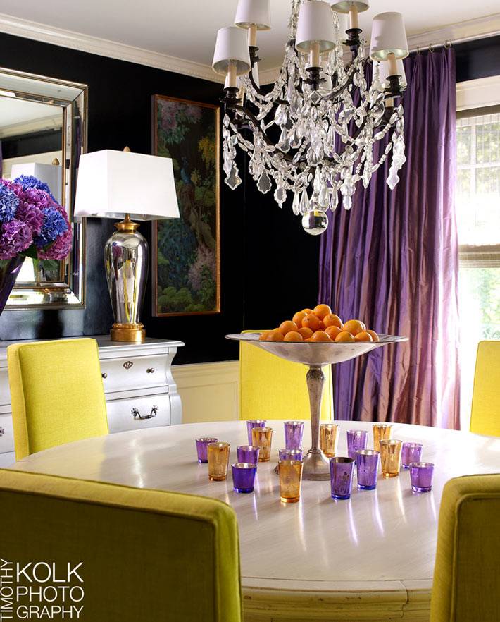 черные стены, фиолетовые шторы и желтые стулья в интерьере столовой комнаты