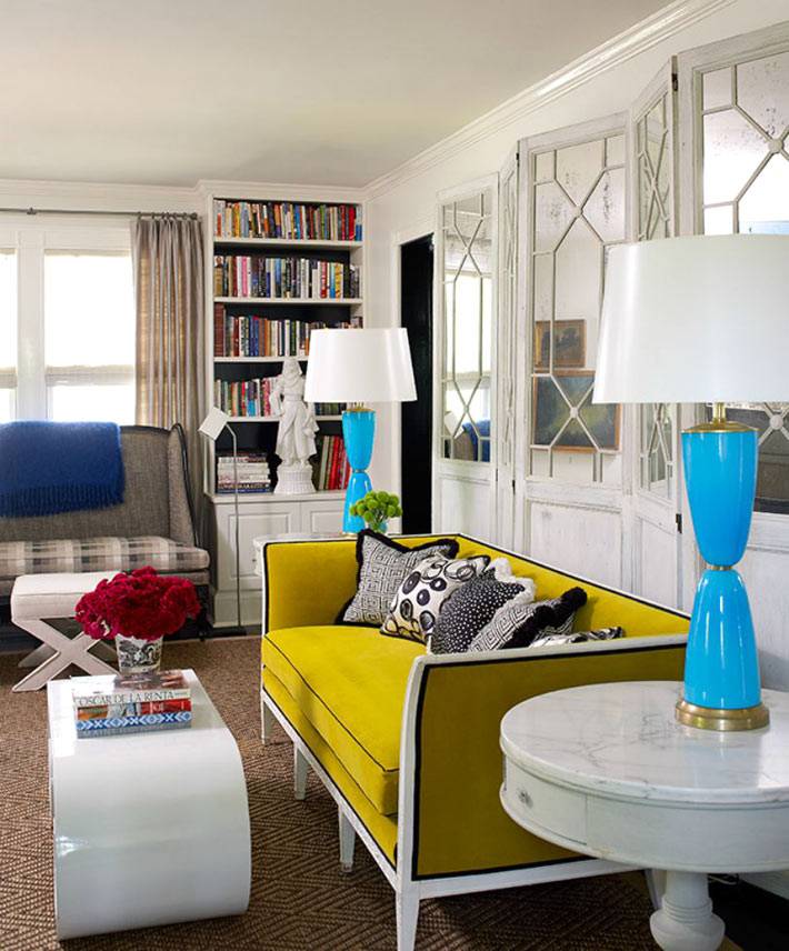 желтый диван и голубые настольные лампы в интерьере гостиной