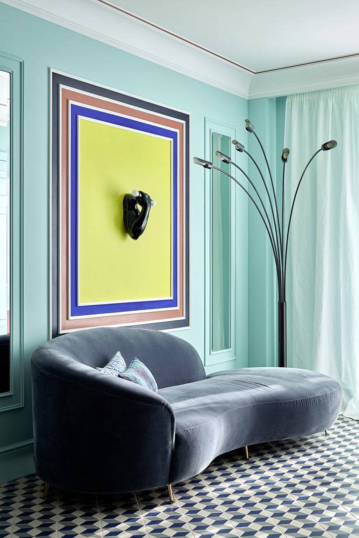 Бирюзовый цвет стен и уникальный диван в гостиной комнате квартиры