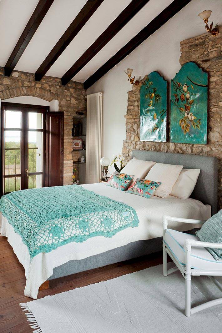 мансардная спальня с бирюзовыми оттенками на картине и кровати