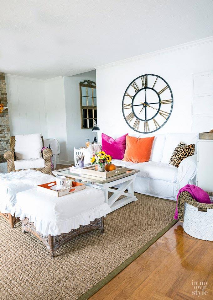 белая гостиной комната с яркими подушками на диване