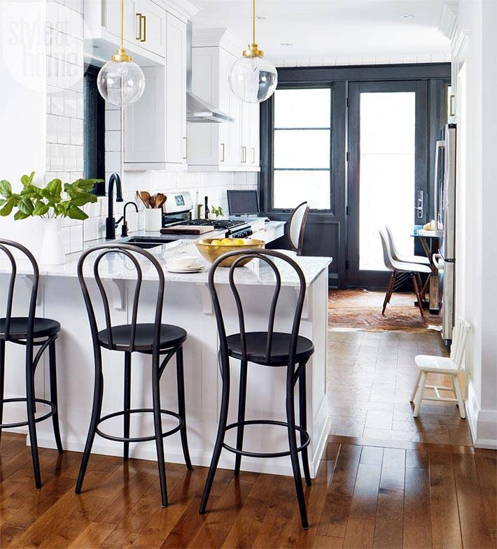 белая кухня с черными стульями и черным окном 