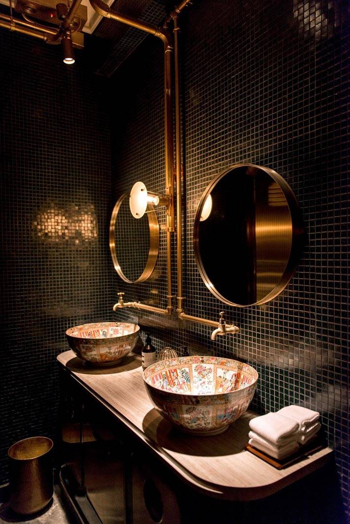 темные стены в ванной комнате и круглые золотые зеркала