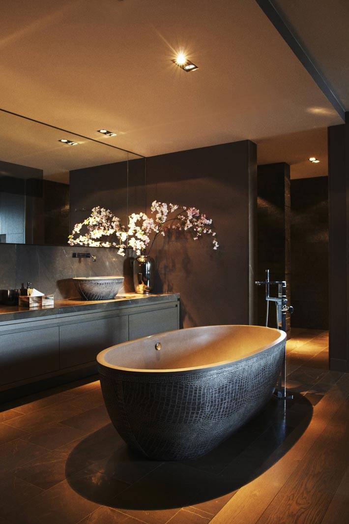 роскошная ванная комната с коричневыми стенами и болльшим зеркалом