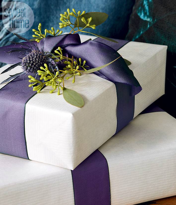 красивая упаковка подарков белой бумагой с фиолетовой лентой