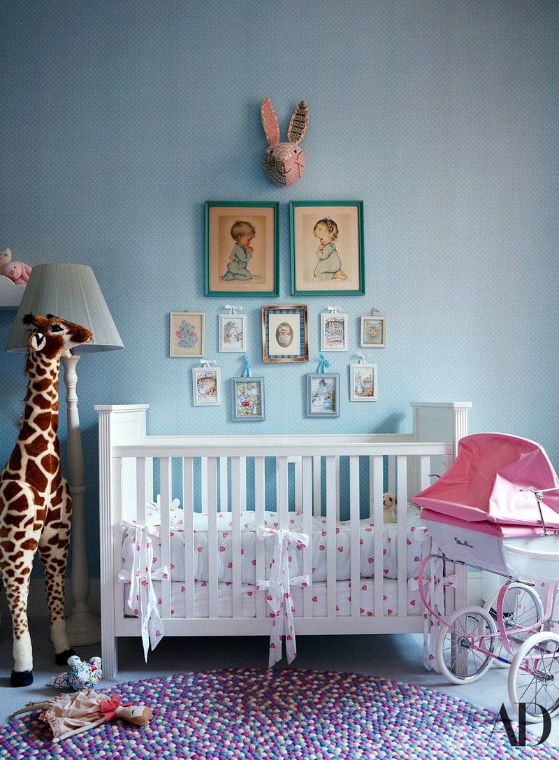 маленькие картинки над белой детской кроваткой и жираф