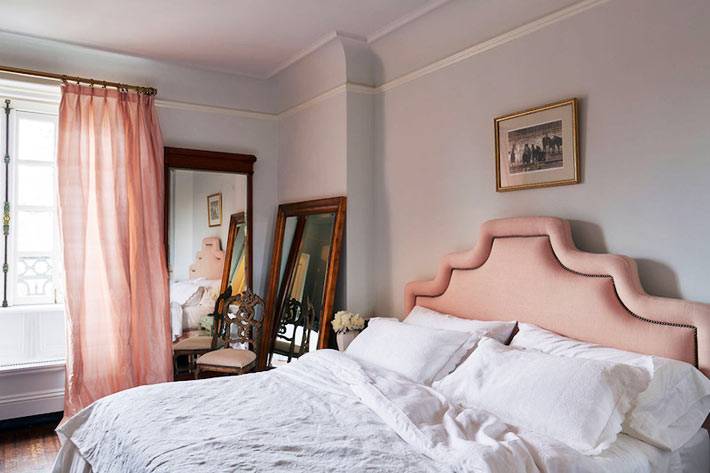 мягкое изголовье кровати и шторы персикового цвета в спальне