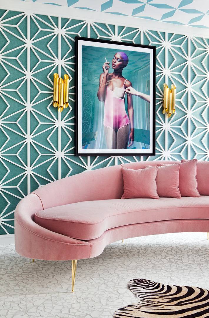 полукруглый диван розового цвета в комнате с бирюзовыми стенами