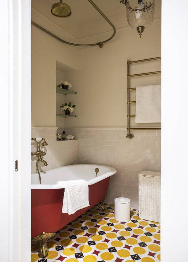 ванна красного цвета, пёстрая красно-жёлтая плитка в ванной