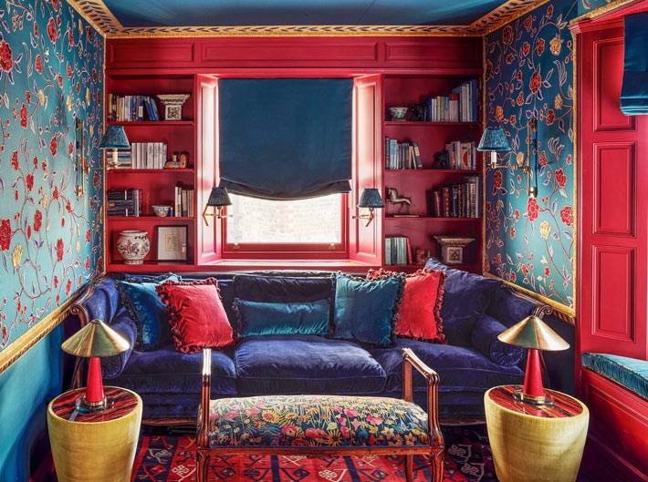 красно-синяя комната с уютным диваном и синим потолком
