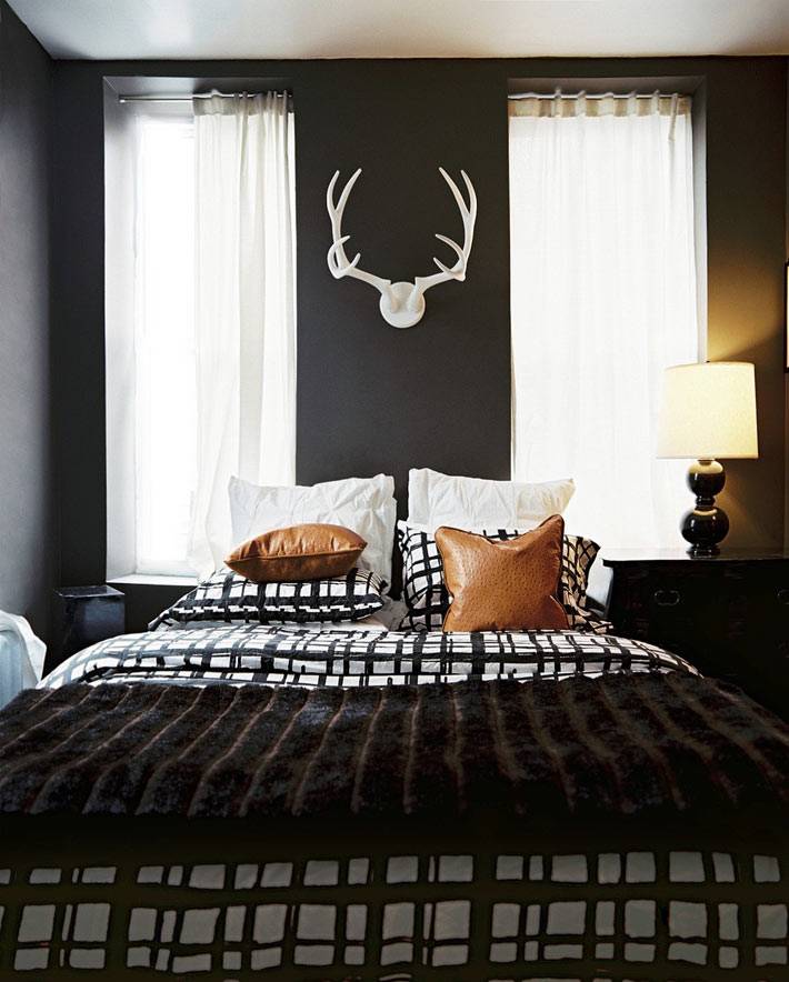 белый рога на черной стене спальни над кроватью